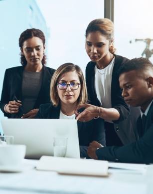 4 attorneys standing around a computer and talking