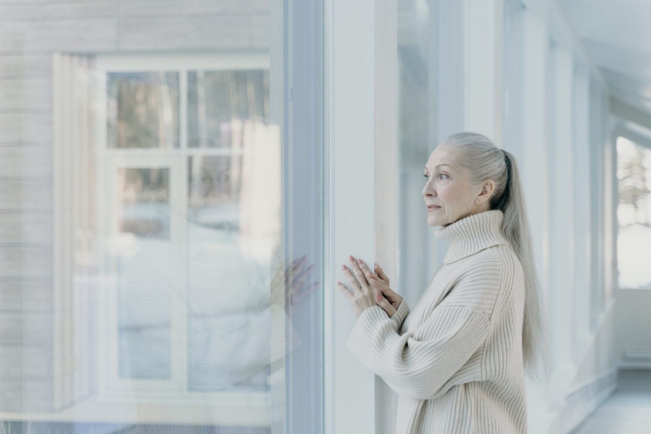 Elderly women starting out a window