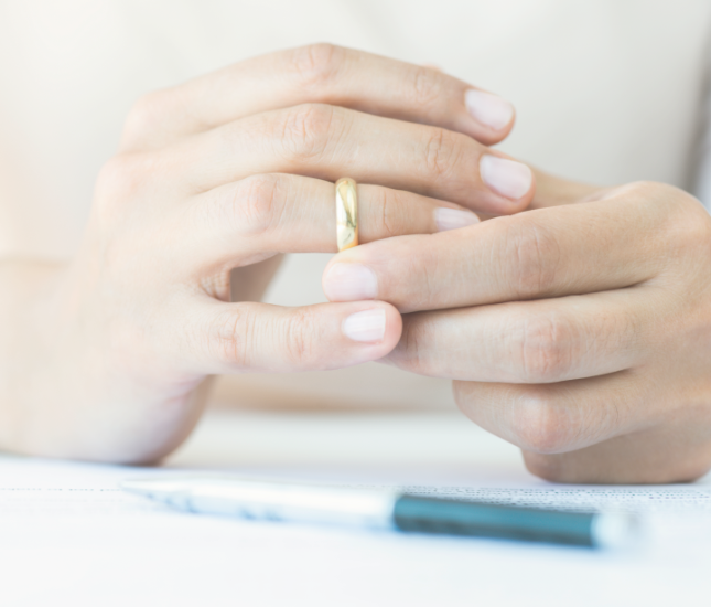 A woman is taking off her wedding ring