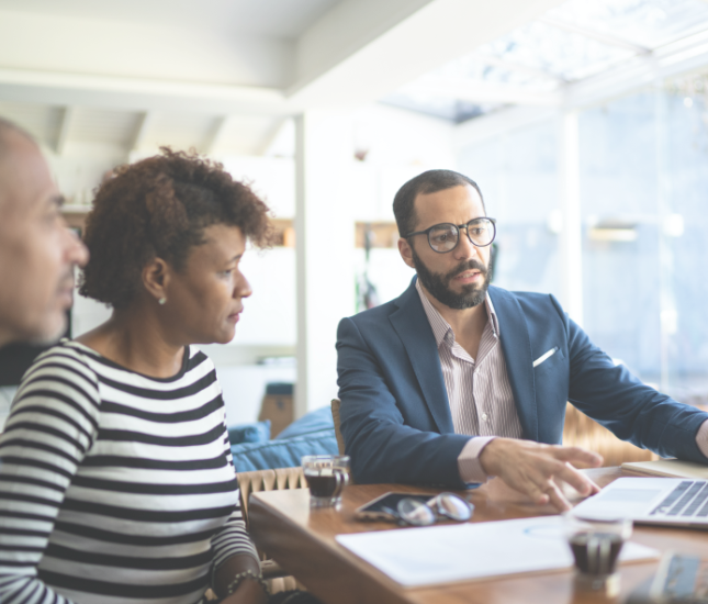 An attorney and a woman are sitting at a table looking at a laptop