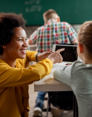 A teacher showing a girl student something on an iPad