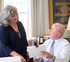 2 lawyers talking to each other while looking at a piece of paper