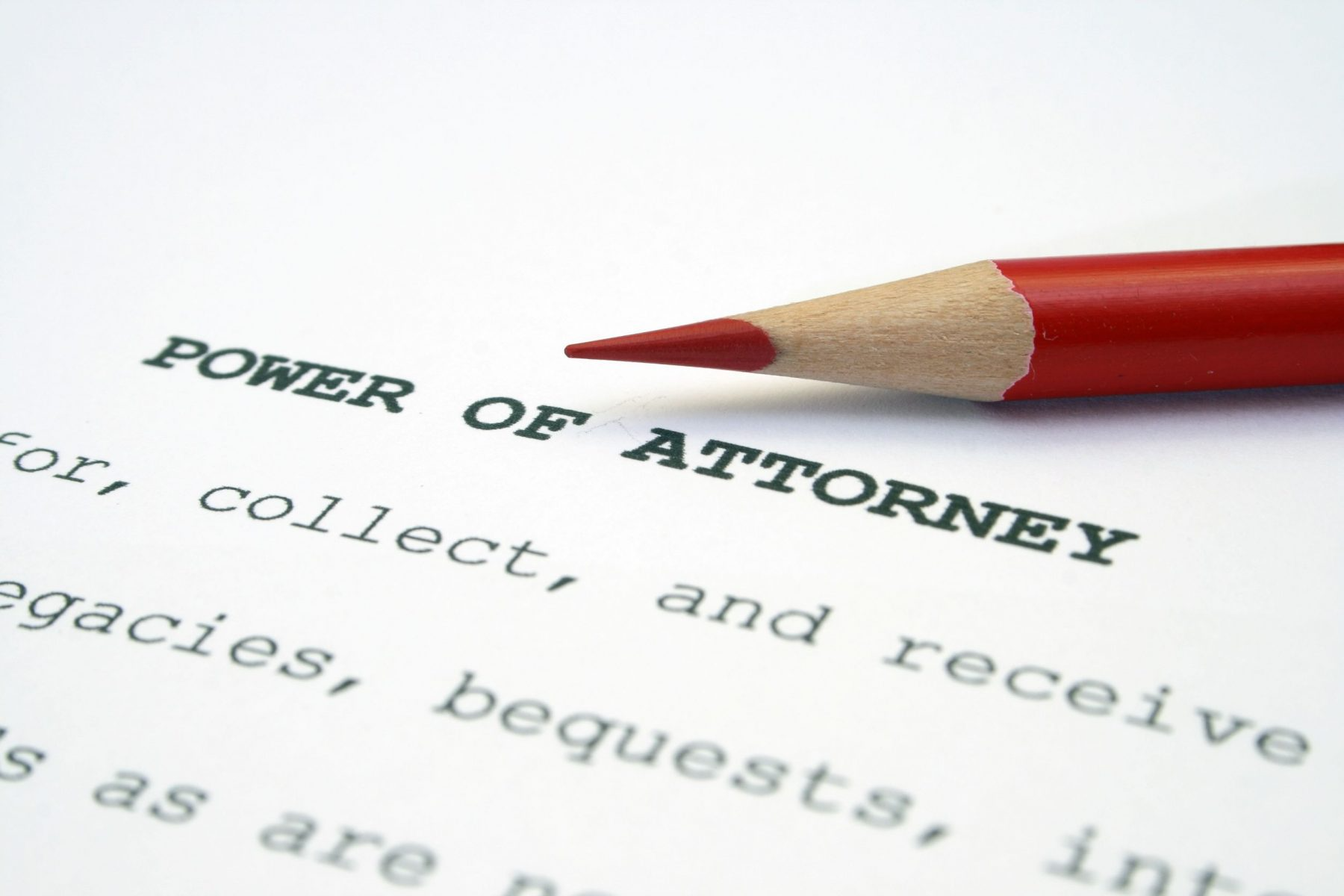 Power of attorney paper with a red pencil laying on top