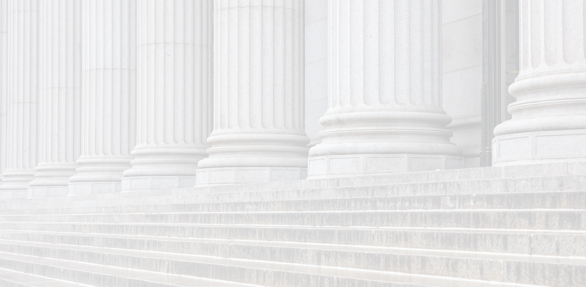 A row of white columns and stairs in front of a building