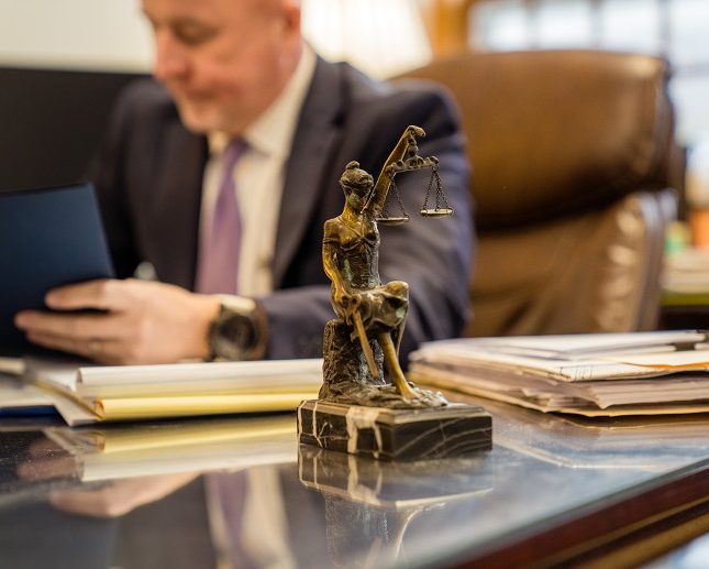employment attorney seated at desk with files and statue