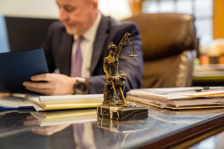 employment attorney seated at desk with files and statue
