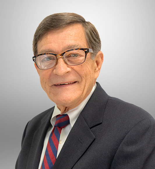 Edmund Myers is wearing glasses and a suit and tie smiles for a headshot