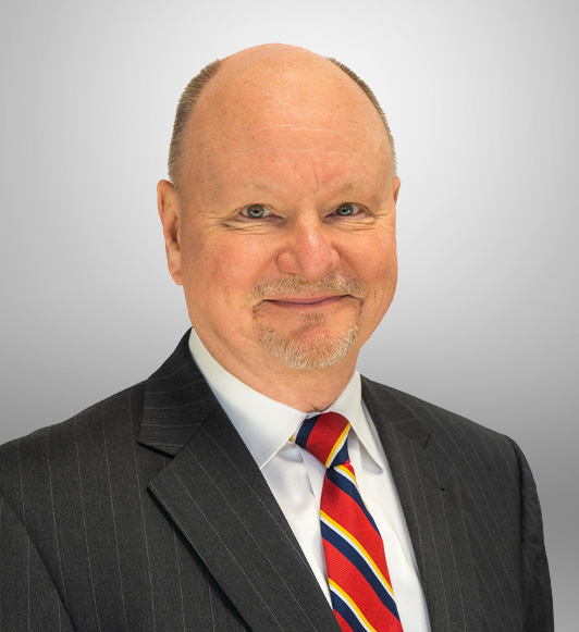 Attorney John Statler in a striped black suit jacket and multicolored tie.