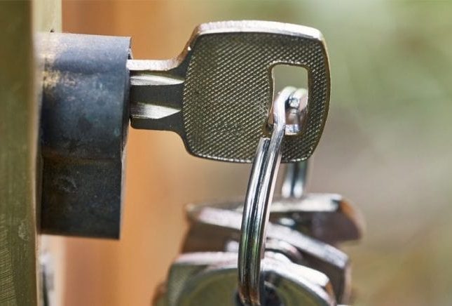 A bunch of keys are hanging on a chain in a lock